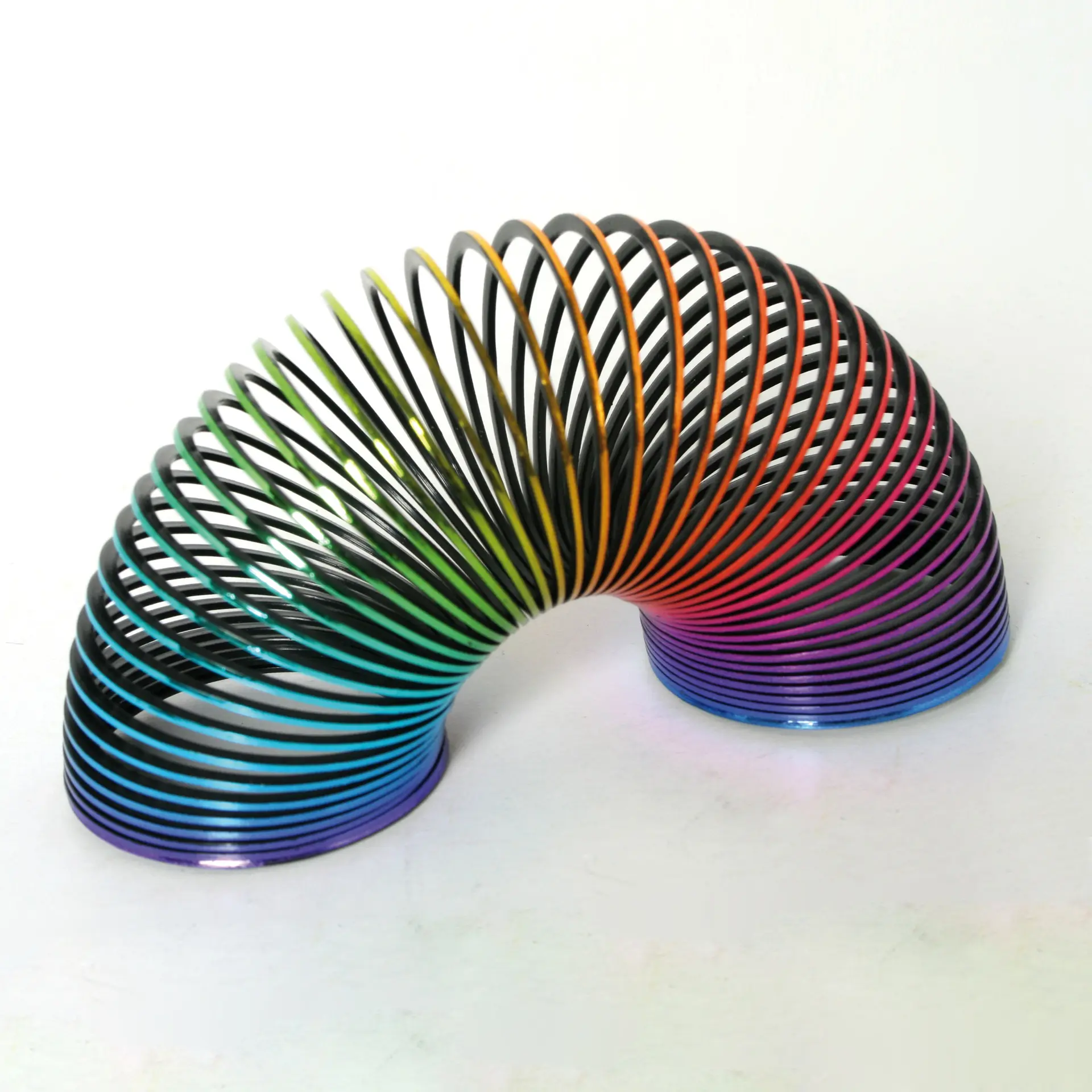 Rainbow plastic magic spring with a metallic finish, shown extended